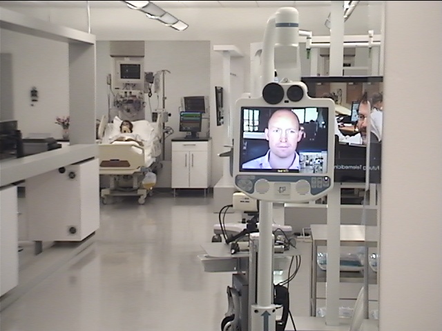 InTouch Health RP-VITA remote presence robot in an ICU corridor, telepresence specialist on screen